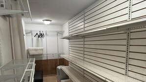 A storage room with metal shelving units, a bench, and a small trash bin. - 2-bedroom, 1 Bath apartment in gorgeous Roslyn with Washer Dryer in unit (Roslyn)