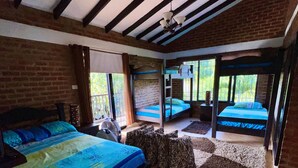 Een slaapkamer met een groot bed, een ventilator en uitzicht op de omgeving.