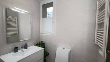 Een haardroger, handdoeken, zeep, toiletpapier