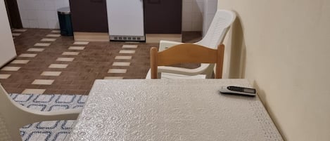 Een koelkast, een kookplaat, kookgerei, borden en bestek