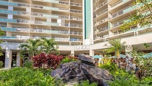 A hotel with multiple balconies, a rock feature, and lush greenery. - Steps to Beach  Resort Amenities  Kitchen (Honolulu)