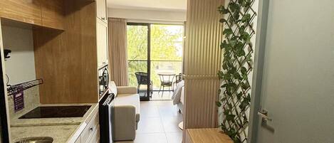 Cocina compacta con lavamanos, armarios y comedor con mesa y sillas.