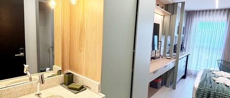 A modern bathroom with a large mirror, dual sinks, and a vanity with a wooden panel design.
