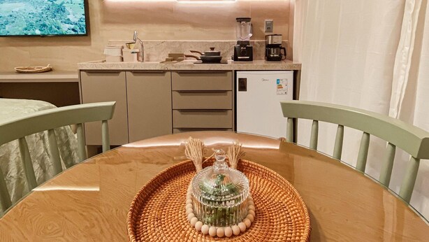 Una cocina compacta con una mesa de comedor, un televisor y un refrigerador.