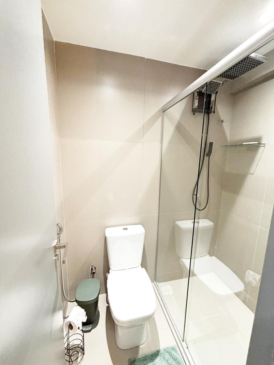 Et badeværelse med en glasafskærmet brusekabine, toilet og bidet.