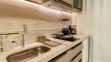 Una cocina moderna con un lavaplatos, estufa y licuadora.