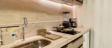 Una cocina moderna con un lavaplatos, estufa y licuadora.