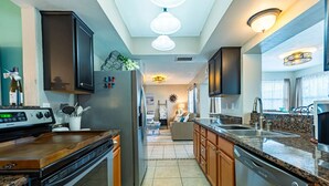 A modern kitchen with granite countertops, stainless steel appliances, and wooden cabinets.