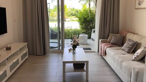 Een moderne woonkamer met een bank, salontafel en televisie aan de muur.