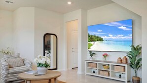 A living room with a sofa, a coffee table, a TV, and a bookshelf.