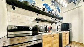 A modern kitchen with stainless steel appliances, wooden cabinets, and a decorative backsplash. - Santurce Skylight – Modern Lofts Stay (San Juan)