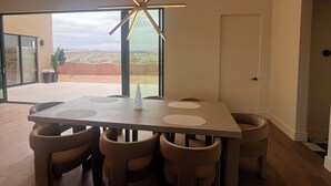 Un comedor moderno con una mesa grande, varias sillas y una lámpara de techo con forma de estrella.