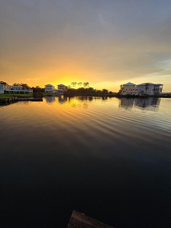 Un lago tranquilo al atardecer con edificios reflejados en el agua.