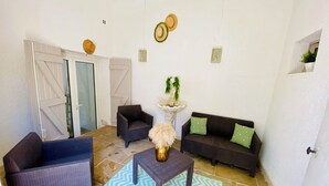 Een woonkamer met een bank, fauteuils, een salontafel en een decoratieve fontein.