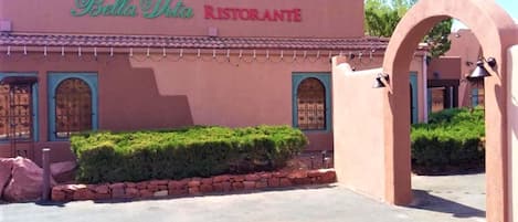 Un edificio con un letrero que dice "Bella Vita Ristorante" y un arco de piedra.