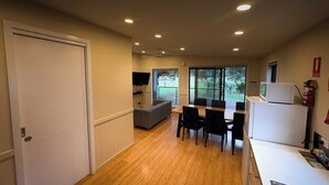 Una cocina compacta con comedor, sofá y televisor.