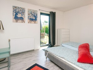 A bedroom with a bed, a radiator, a desk, and a window with curtains. - 4 Star Holiday Home in Haderslev (Haderslev)