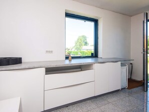 A kitchen with a window, white cabinets, and a countertop. - 4 Star Holiday Home in Haderslev (Haderslev)