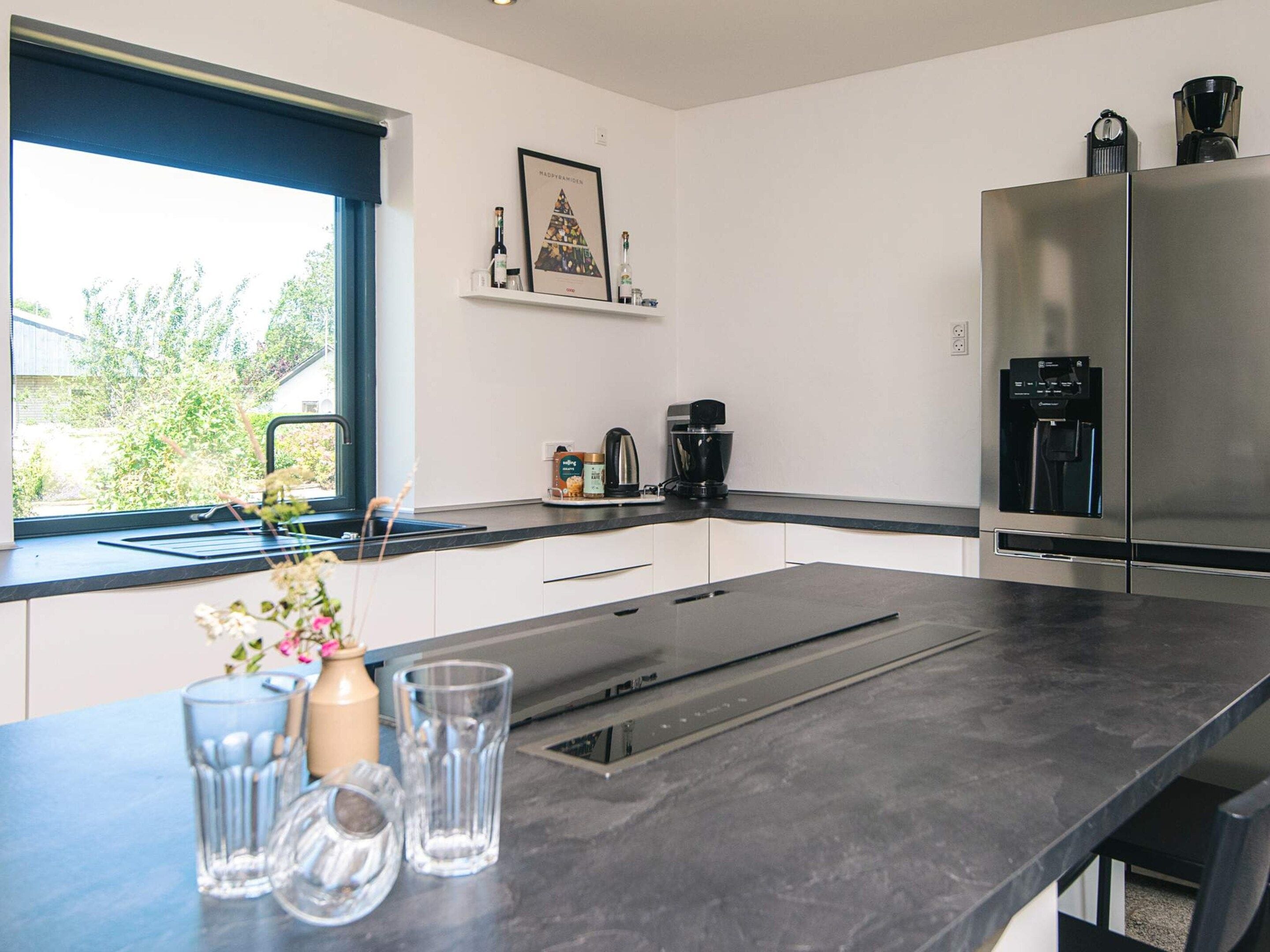 A modern kitchen with a built-in stove, a coffee maker, and a water dispenser.