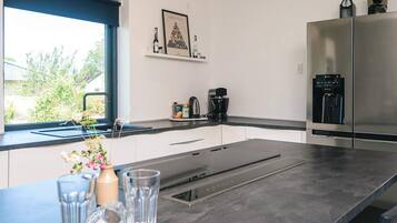 A modern kitchen with a built-in stove, a coffee maker, and a water dispenser.