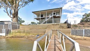 A modern building with a wooden deck leading to a staircase. - 142 Page Drive - Alls Well (Blanchetown)