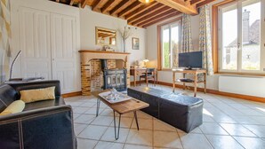 A cozy living room with a fireplace, a television, and a comfortable seating area.