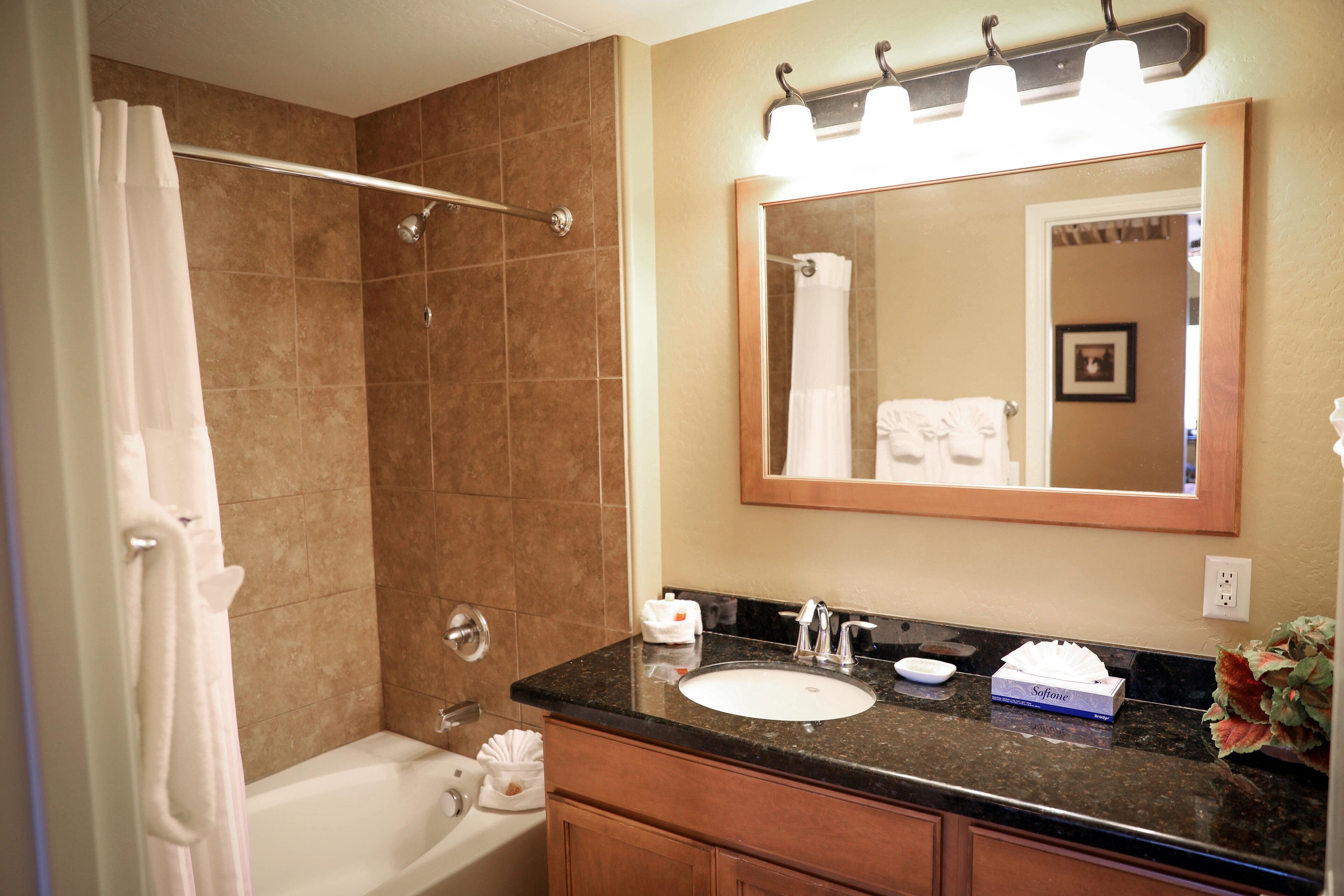A bathroom with a bathtub, a sink, a mirror, and a shower.