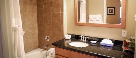 A bathroom with a bathtub, a sink, a mirror, and a shower.