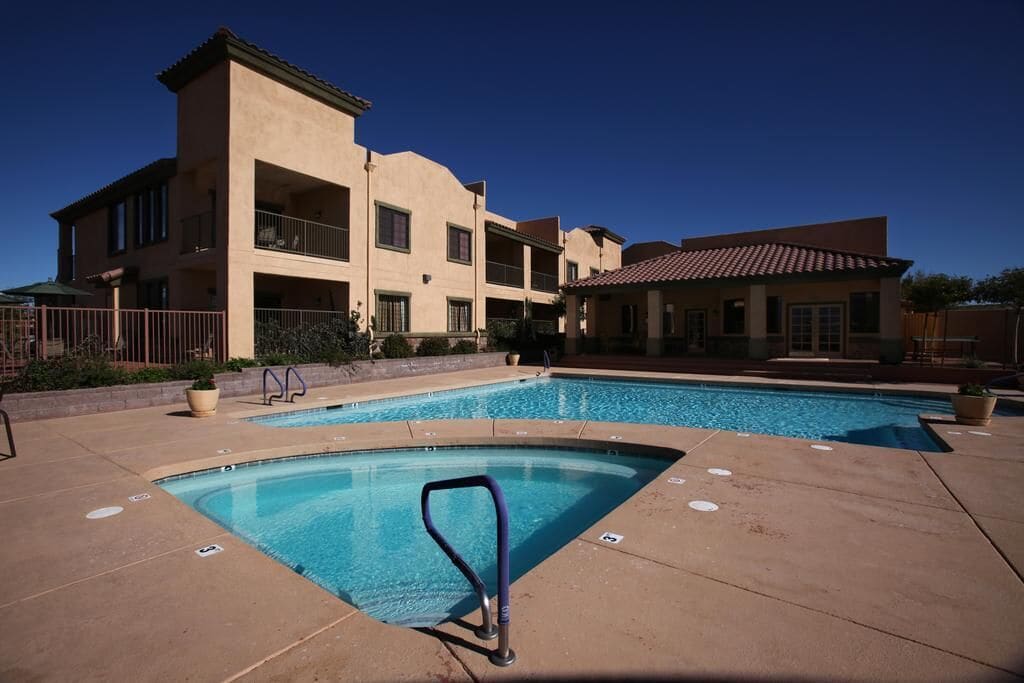 A swimming pool area with a building in the background.