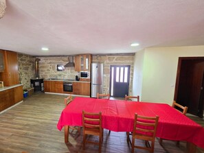 A spacious kitchen with wooden cabinets, a built-in oven, and a refrigerator. - Casa do Carvalhal | Ermida | Peneda-Gerês National Park (Ponte da Barca)