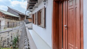 Un bâtiment doté d’un balcon, d’une porte en bois et d’un mur en pierre.