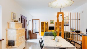 Un coin repas comprenant une table, des chaises, un vase avec des fleurs et un buffet en bois.