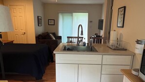 A compact living space with a kitchenette, a ceiling fan, a bed, a dining area, and a view of the outdoors. - Piermont Oasis (Piermont)