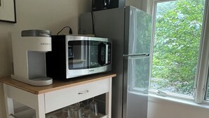 A compact kitchen with a microwave, kettle, and refrigerator. - Piermont Oasis (Piermont)