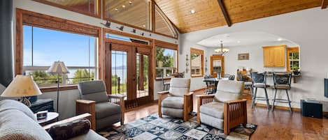 A spacious living area with a large window, a fireplace, and a cozy seating arrangement.