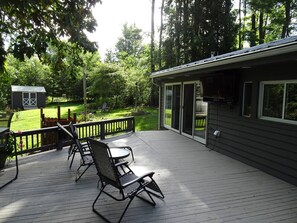 A deck with outdoor furniture and a building with large windows.