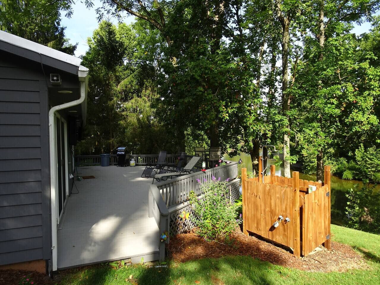 A covered patio area with outdoor furniture, a wooden play structure, and a house in the background.