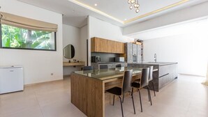 Une cuisine moderne dotée d’un îlot central, de meubles en bois et d’une grande fenêtre.