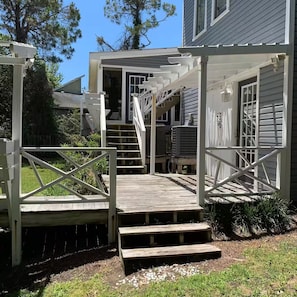 A wooden deck with a covered entrance leading to a house. - Argyles Too! A brand new Loft Efficiency (Kitty Hawk)