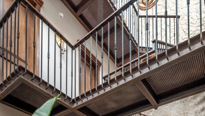 A spacious indoor area with a staircase, wooden doors, and potted plants. - Casa Sonara (Cartagena)
