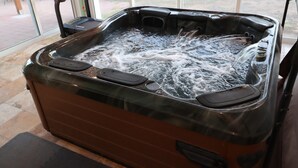 A hot tub with a glass enclosure, visible water jets, and a control panel. - Relaxing Corner -Huge backyard - Hot Tub and Views (Tucson)