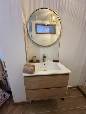 Chuveiro, secador de cabelo, toalhas de banho, papel higiênico