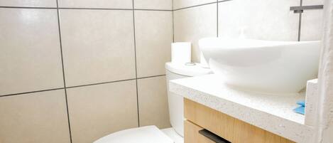 A bathroom with a toilet, a sink, and a cabinet.