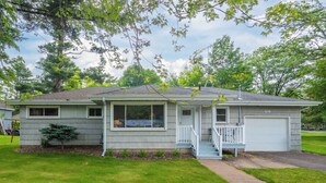 A single-story house with a front porch, a garage, and a small front yard.
