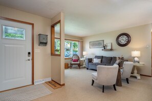 A living room with a sofa, chairs, a coffee table, a clock, and a door with a window. - Walking distance to public beach, boat landing,  and downtown Balsam Lake (Balsam Lake)