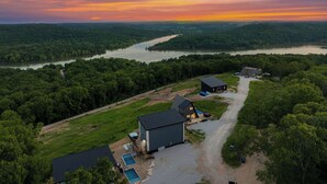 A large house with a swimming pool, surrounded by dense forest and a river. - Lux Lakeview • Pool, Hot Tub, Game Room, EpicViews (Omaha)