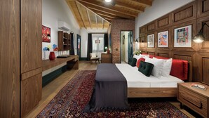 A bedroom with a wooden ceiling, a large bed with red and white bedding, a red vase, and a patterned rug. - Tinspiro Alaçatı (Cesme)