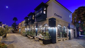 A building with a sign reading "CASPIRÓ" and a courtyard with outdoor seating. - Tinspiro Alaçatı (Cesme)