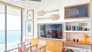 A modern living room with a large TV, wooden furniture, and a view of the sea. - New KeyPöint: Long stays in Pözos Colorados! (Santa Marta)