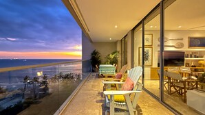 A balcony with a view of the sunset over the ocean, furnished with chairs and a dining area. - New KeyPöint: Long stays in Pözos Colorados! (Santa Marta)